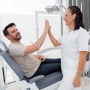 Dental patient high-fiving a member of his care team